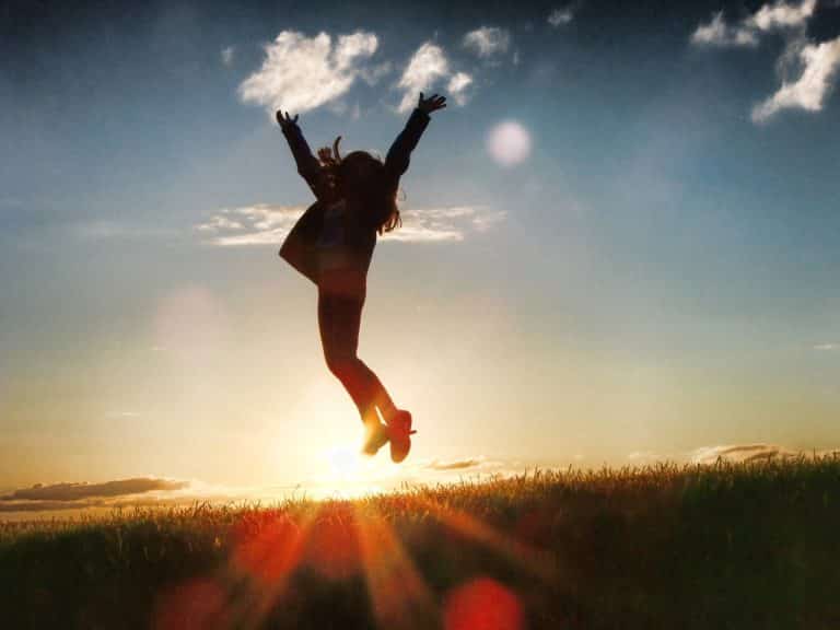 teen jumping up in the air at sunset